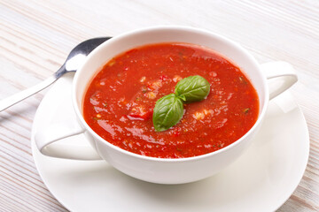 Gazpacho in a white plate and basil