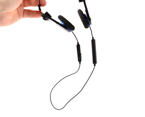 man's hand holds classic black headphones with bluetooth headset. isolated background. music listening concept.