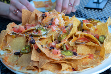 Tacos on a plate with cheese, olive, onion, pimento