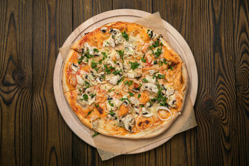 Pizza with cheese, herbs and meat in an Italian pizzeria
