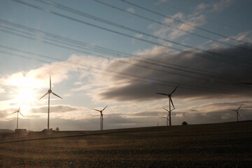 Fototapeta na wymiar Windpark mit Windrädern zur Erzeugung regenerativer Energie für die Energiewende mit Regenwolke im Licht der Abendsonne in Gembeck am Twistetal im Landkreis Waldeck-Frankenberg in Hessen