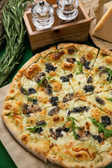 Pizza with cheese, herbs and mushrooms in an Italian pizzeria
