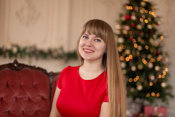 Portrait of a beautiful smiling blonde girl near the Christmas tree