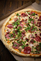 pizza with sausage, cheese, tomatoes and herbs
