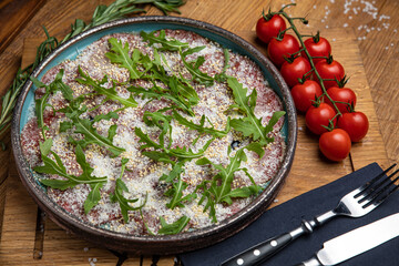Veal carpaccio with cheese and arugula
