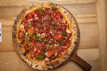pizza with sausage, cheese, tomatoes and herbs
