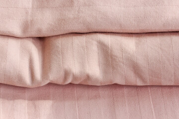 Bed linen on the bed in the room Home textiles as part of the interior Pink satin sheets.