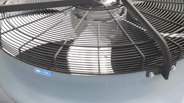 Air conditioner unit fan rotating. Industrial air conditioning system on the wall outdoors.