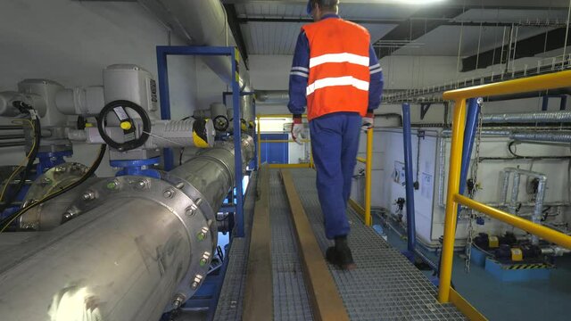The worker checks the valves behind the compressors of the high-pressure biogas circuit in the cogeneration plant.