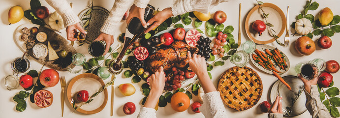 Autumn Thanksgiving, Friendsgiving, family party dinner. Flat-lay of peoples hands eating and drinking over table with roasted duck, vegetables, cheese board and apple pie, top view - 384653210