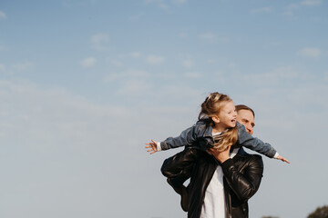 Fototapeta premium Cheerful father playing with little daughter outdoors
