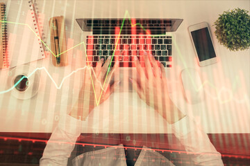 Double exposure of woman hands working on computer and forex chart hologram drawing. Top View. Financial analysis concept.