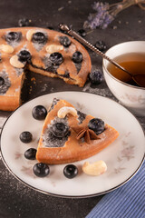 a piece of Christmas cake with berries and a cup of tea