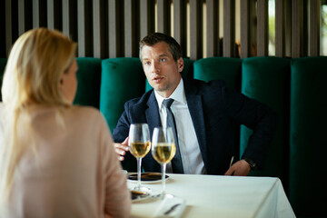Handsome businessman dressed in the suit drinking wine. Businessman enjoying in the restaurant