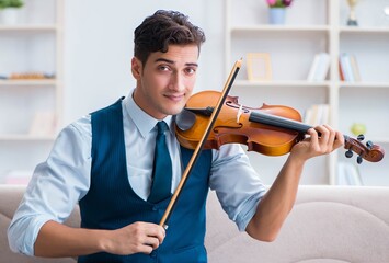 Young musician man practicing playing violin at home