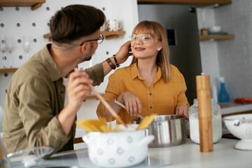 Young couple preparing delicious food at home. Loving couple enjoying in the kitchen.