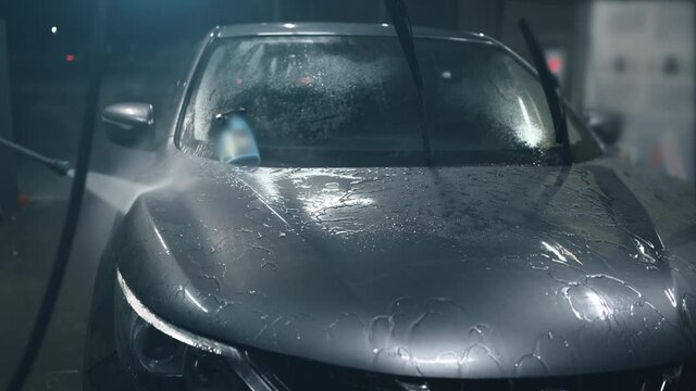 Washing car made of high pressure water covered with protective ceramic hydrophobic layer, car care and detailing concept.