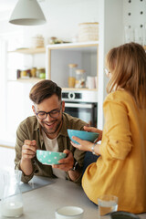 Young couple eating breakfast at home. Loving couple enjoying in the kitchen..