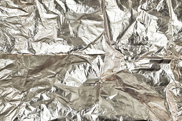 Shiny crumpled aluminum foil texture background. Shiny silver surface