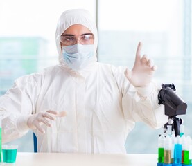 Young chemist pressing virtual buttons in lab