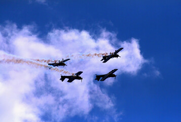 Attractive air show at the airport sports airport. Four airplanes flying upside down in the sky above the clouds.