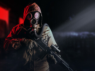 Photo of a post apocalyptic stalker soldier in gas mask and hood jacket holding rifle and standing on dark factory background with red light glow. © breakermaximus