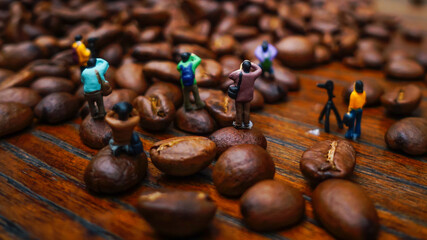 miniature of group photographer taking picture around coffee beans on wooden table 