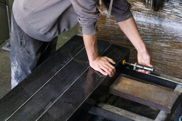 Worker fixes the granite blanks before starting work.