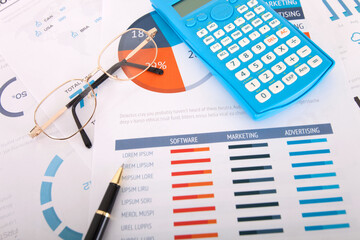 Obraz premium Calculator and signature pen and a pair of glasses on financial documents