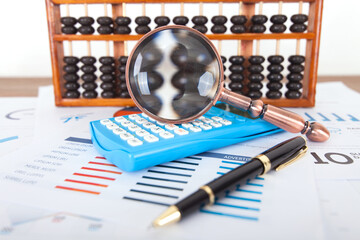 The magnifying glass placed on the calculator is observing the abacus beads on the abacus