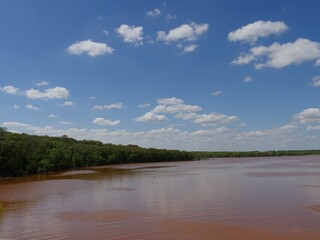 Beautiful clouds over the reddish waters of Thunderbird Lake, Oklahoma.