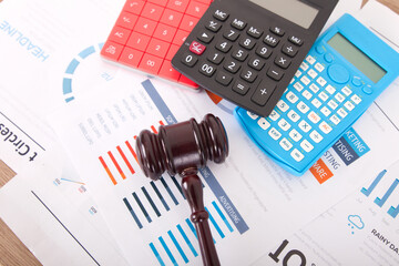 Calculator and law hammer on financial documents background