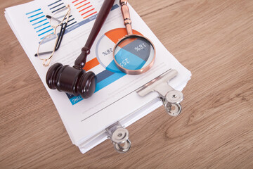 Neatly stacked stack of business documents, magnifying glass and hammer