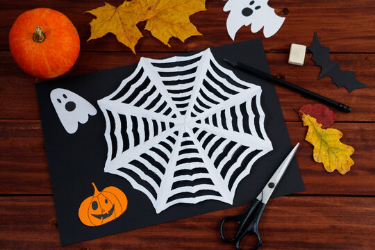 Halloween DIY crafts. Spider web cut from paper. Children's creativity.