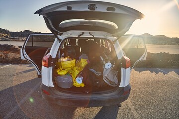 Trunk of a car loaded with travel camping equipment in Iceland - 384664653