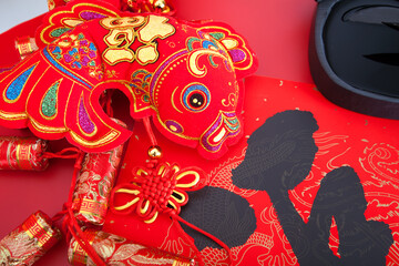 Fototapeta premium Red goldfish hanging ornament on red background.The Chinese characters on spring couplets and hanging fish mean 