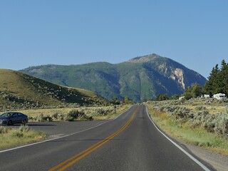 Wyoming, USA--July 2018: Paved road with vehicles parked on the sides near Mammoth Hot Springs at Yellowstone National Park.