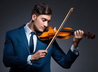 Young man playing violin in dark room