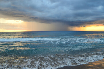 A rain cell darkens the skies off of the town of Rincon on the northwestern coast of Puerto Rico.