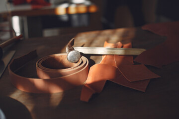 Man working with leather. Professional makes a belts.