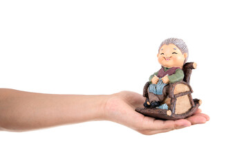 Holding an old woman model in her hand in front of a white background