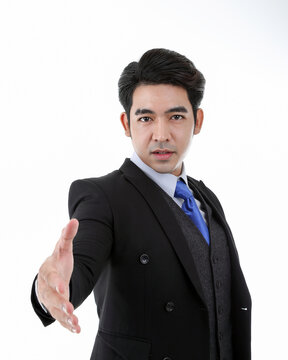 Southeast Asian young office business man wearing suit extend hand for handshake look at camera on white studio background