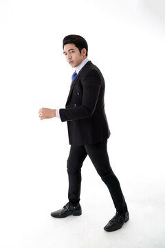 Southeast Asian young office business man wearing suit turn back look at camera on white studio background