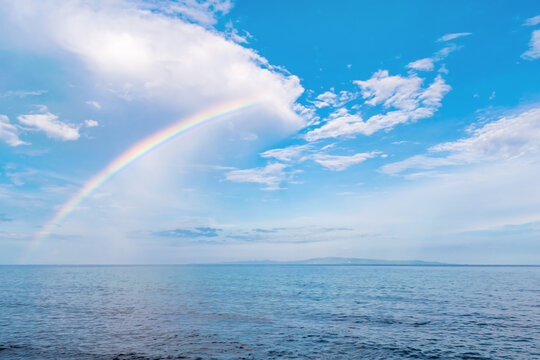 Beautiful colorful rainbow after rain against the blue sky. Background image