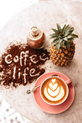 Pink cup of cappuccino on marble table background. Love latte art on the top of it.