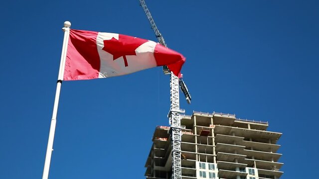 Canadian flag with apartment building under construction in the background, Canadian economy and housing market. HD 24FPS.