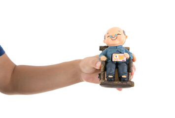 Holding an old man model in one hand in front of white background