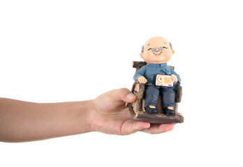 Holding an old man model in one hand in front of white background