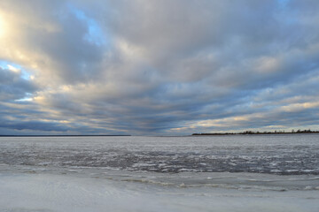 Icy background, frozen sea covered with ice, against the backdrop of a magnificent evening sky.