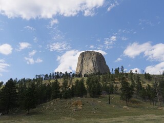 Fototapeta na wymiar Wide shot of the Devils Tower in Wyoming with beautiful clouds in the skies.